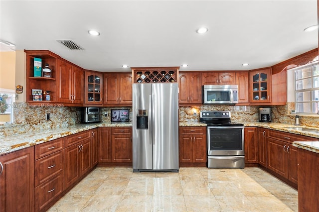 5933 SW 151st Pl, Miami, FL 33193 - kitchen featuring stainless steel appliances, decorative backsplash, light stone counters, recessed lighting, and glass insert cabinets