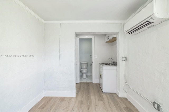washroom with crown molding, baseboards, a wall unit AC, and light wood-type flooring