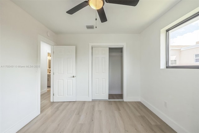 unfurnished bedroom with a ceiling fan, visible vents, baseboards, a closet, and light wood-style floors