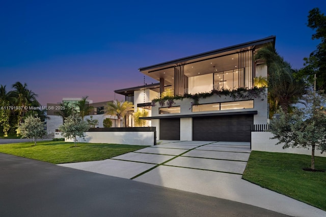 11404 N Bayshore Dr, North Miami, FL 33181 - contemporary home featuring concrete driveway, an attached garage, a balcony, a front yard, and stucco siding