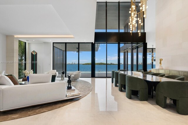 11404 N Bayshore Dr, North Miami, FL 33181 - living room featuring floor to ceiling windows, a water view, a chandelier, and healthy amount of natural light