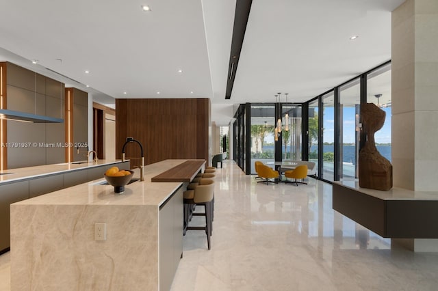 11404 N Bayshore Dr, North Miami, FL 33181 - kitchen with modern cabinets, floor to ceiling windows, a sink, light marble finish flooring, and a spacious island