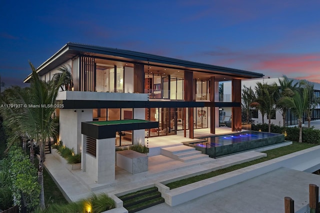 11404 N Bayshore Dr, North Miami, FL 33181 - back of property with a balcony, an infinity pool, a patio area, and a hot tub
