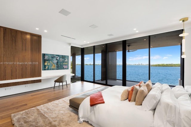 11404 N Bayshore Dr, North Miami, FL 33181 - bedroom featuring a wall of windows, access to outside, wood finished floors, recessed lighting, and a water view