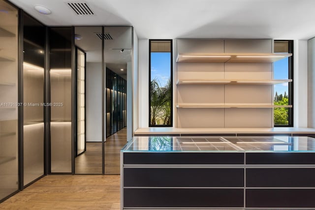 11404 N Bayshore Dr, North Miami, FL 33181 - kitchen featuring open shelves, wood finished floors, stainless steel counters, and expansive windows