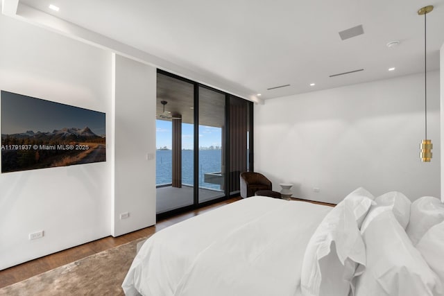 11404 N Bayshore Dr, North Miami, FL 33181 - bedroom featuring access to exterior, a wall of windows, a water view, wood finished floors, and recessed lighting