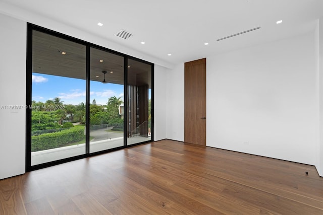 11404 N Bayshore Dr, North Miami, FL 33181 - spare room featuring wood finished floors, floor to ceiling windows, and recessed lighting