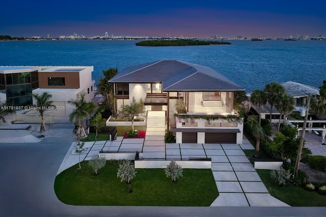 11404 N Bayshore Dr, North Miami, FL 33181 - view of front of property featuring a water view, a balcony, driveway, stairway, and stucco siding