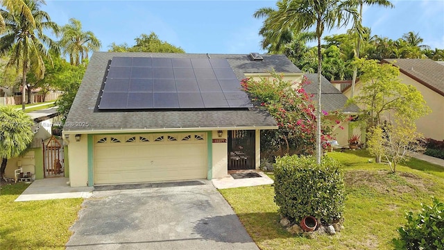 view of front of house featuring roof with shingles, stucco siding, solar panels, and driveway