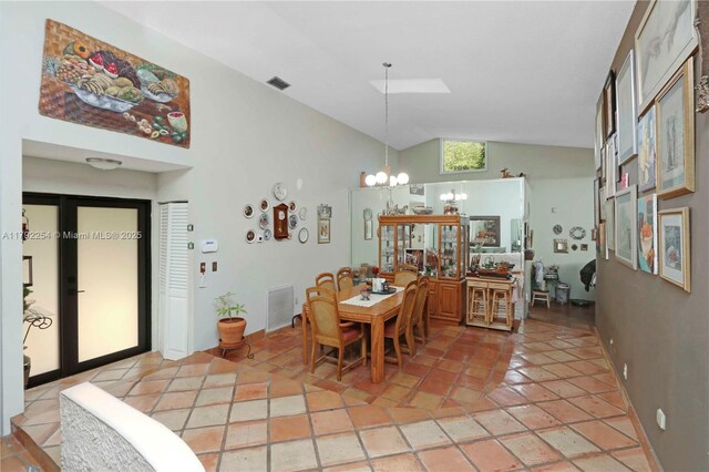 dining area featuring an inviting chandelier, visible vents, and high vaulted ceiling