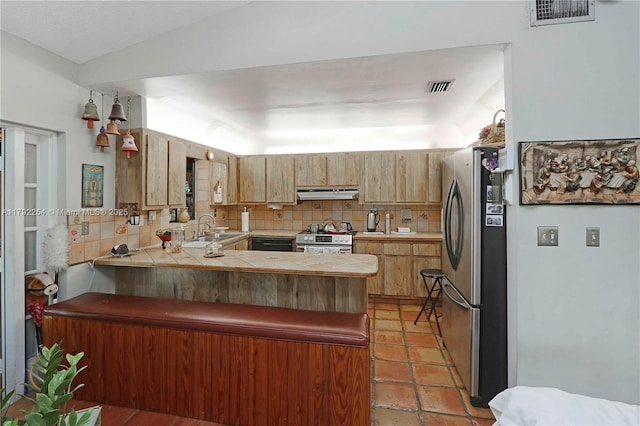kitchen with visible vents, appliances with stainless steel finishes, a sink, a peninsula, and under cabinet range hood