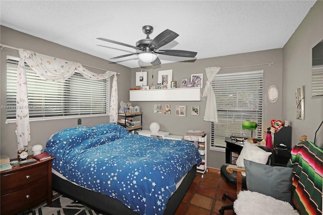 bedroom featuring tile patterned flooring, a textured ceiling, and multiple windows