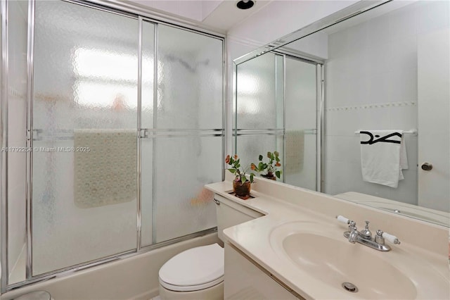 full bathroom with vanity, enclosed tub / shower combo, and toilet