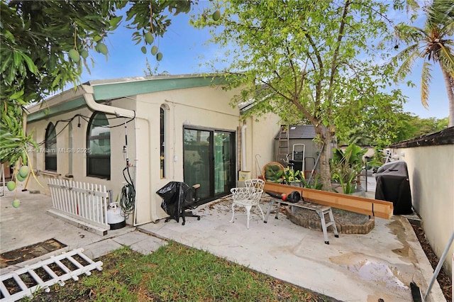 back of house with a patio and stucco siding