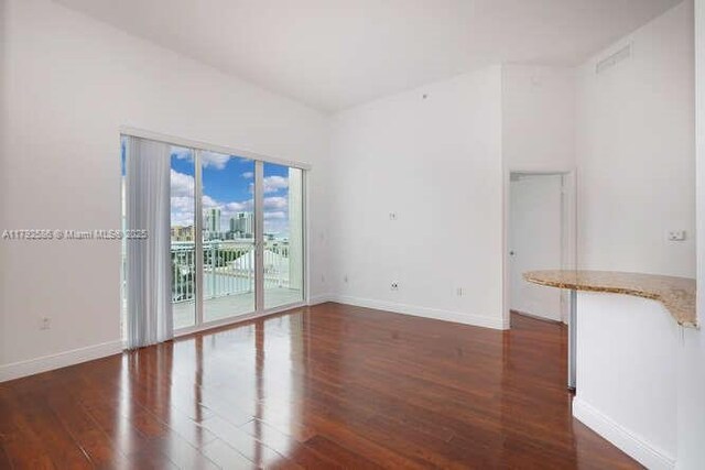 7280 SW 90th St Unit 703, Miami, FL 33156 - spare room featuring baseboards, wood finished floors, and visible vents