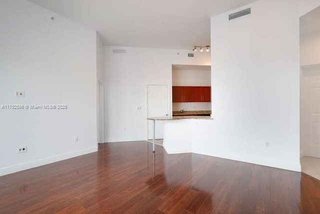 7280 SW 90th St Unit 703, Miami, FL 33156 - unfurnished living room with rail lighting, visible vents, and wood finished floors