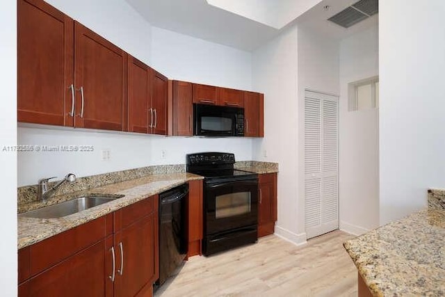7280 SW 90th St Unit 703, Miami, FL 33156 - kitchen featuring light stone countertops, a sink, light wood finished floors, visible vents, and black appliances