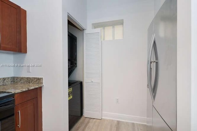 7280 SW 90th St Unit 703, Miami, FL 33156 - washroom featuring laundry area, baseboards, and light wood-style floors