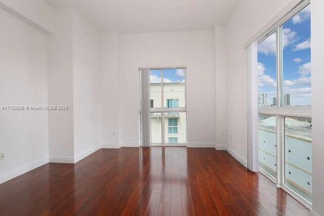7280 SW 90th St Unit 703, Miami, FL 33156 - spare room with baseboards, hardwood / wood-style floors, and a wealth of natural light