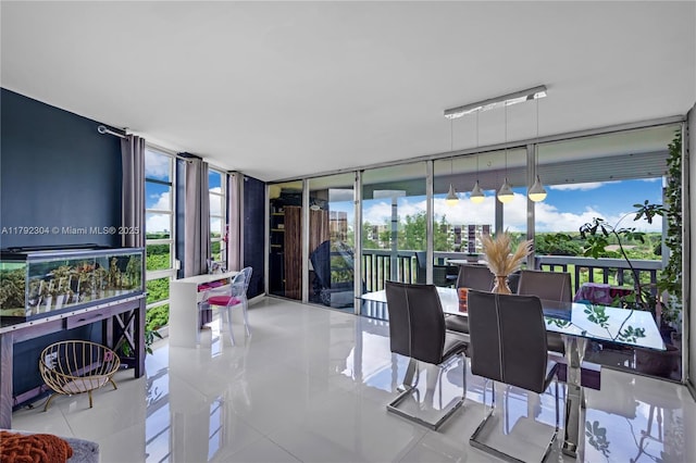 sunroom featuring a wall of windows, tile patterned floors, and plenty of natural light