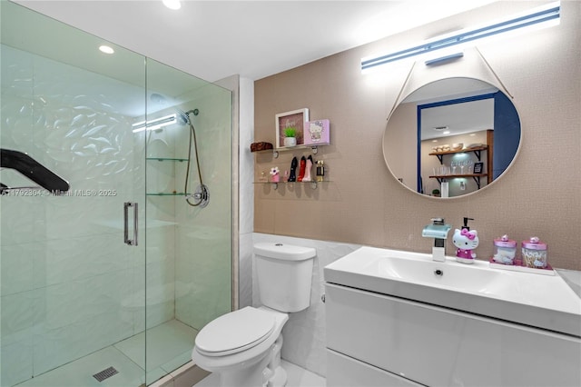 bathroom with tile walls, a stall shower, vanity, toilet, and recessed lighting