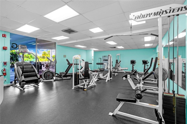 exercise room featuring a paneled ceiling and visible vents