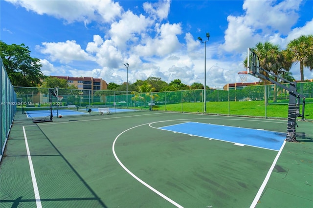view of basketball court with community basketball court, fence, and a tennis court