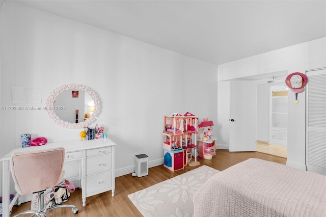bedroom featuring baseboards, light wood-style flooring, and ensuite bathroom