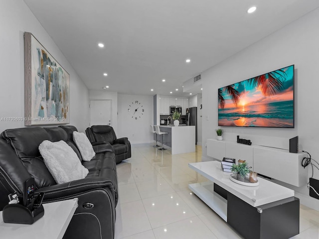 living room with light tile patterned floors, baseboards, recessed lighting, and visible vents