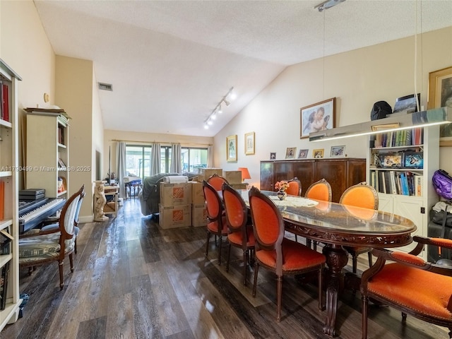 dining space with visible vents, wood-type flooring, rail lighting, and lofted ceiling