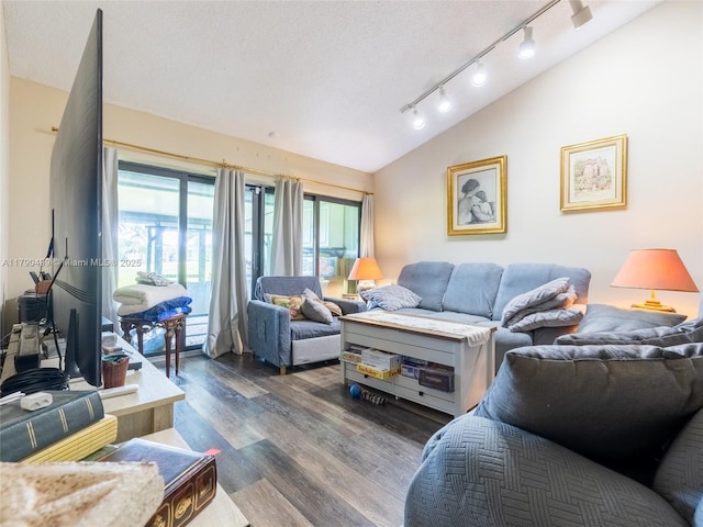 living room featuring track lighting, dark wood-style flooring, and vaulted ceiling