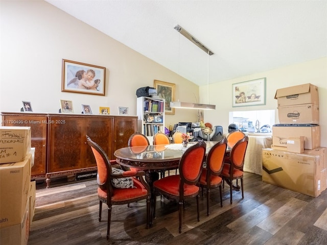 dining space featuring wood finished floors and lofted ceiling