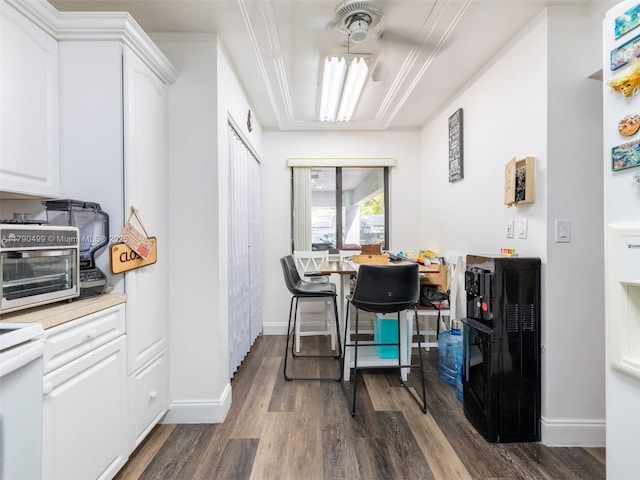 dining room featuring a toaster, baseboards, and dark wood-type flooring