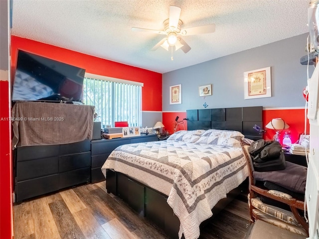 bedroom with a textured ceiling, ceiling fan, and wood finished floors