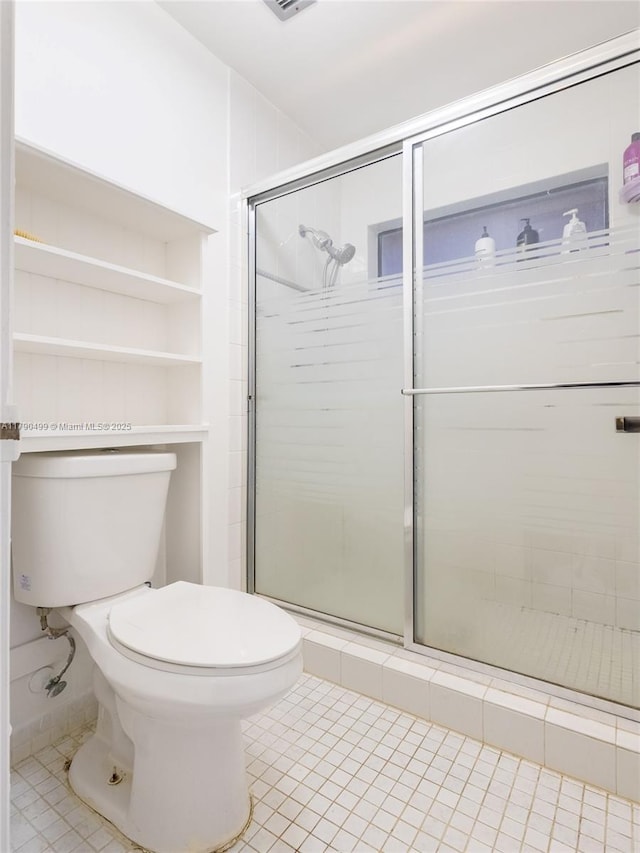 bathroom featuring toilet, tile patterned floors, visible vents, and a shower stall