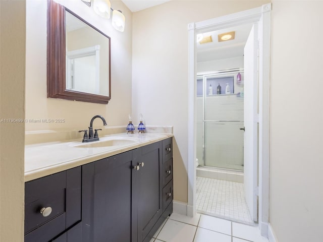 bathroom featuring vanity, tile patterned flooring, baseboards, and a shower stall