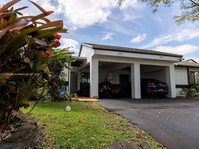 view of home's exterior featuring a lawn, driveway, and a carport