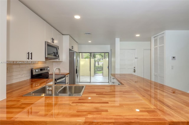 3905 Adra Ave Unit J-46B, Doral, FL 33178 - kitchen with appliances with stainless steel finishes, butcher block countertops, tasteful backsplash, recessed lighting, and white cabinetry