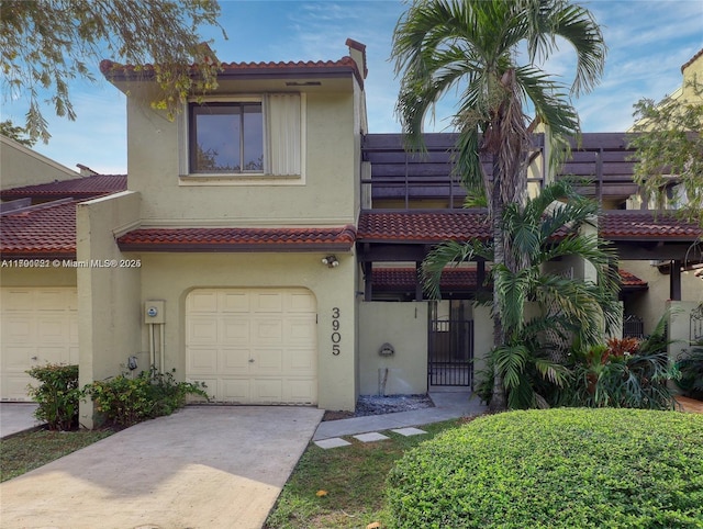 3905 Adra Ave Unit J-46B, Doral, FL 33178 - view of front of property with concrete driveway, stucco siding, an attached garage, and a tile roof