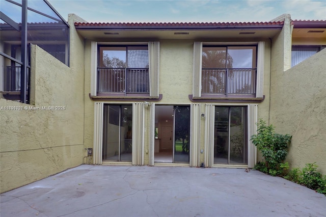3905 Adra Ave Unit J-46B, Doral, FL 33178 - rear view of property with a patio, stucco siding, and glass enclosure