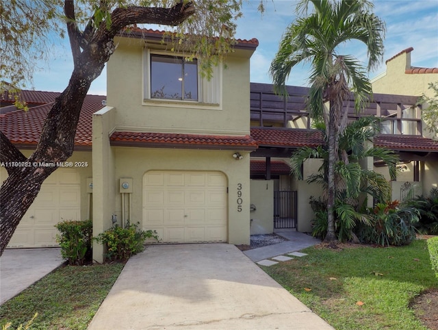 3905 Adra Ave Unit J-46B, Doral, FL 33178 - mediterranean / spanish house featuring stucco siding, driveway, a garage, and a tiled roof