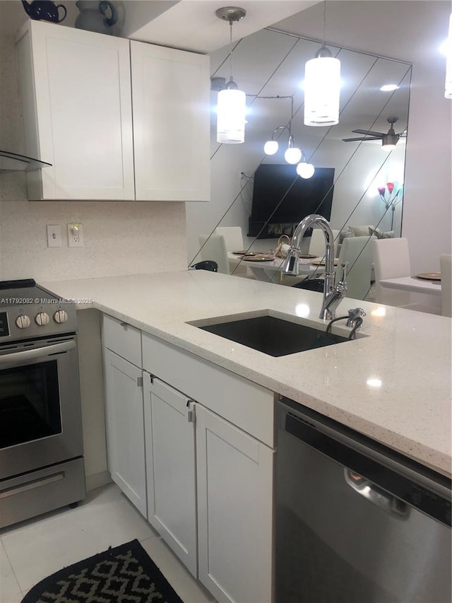 1101 Bahama Bnd Unit B2, Coconut Creek, FL 33066 - kitchen featuring light stone countertops, wall chimney exhaust hood, white cabinets, a sink, and stainless steel appliances
