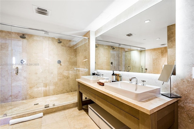 bathroom featuring visible vents, a sink, and a stall shower
