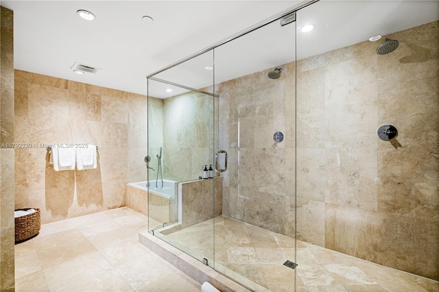 full bathroom featuring tile walls, a stall shower, recessed lighting, and visible vents