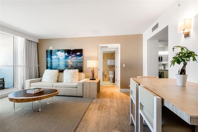 living area with light wood-style floors and visible vents