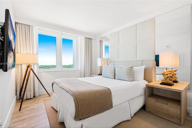 bedroom with baseboards and light wood-type flooring