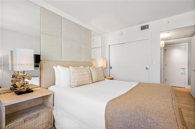 bedroom featuring visible vents, wood finished floors, and a closet