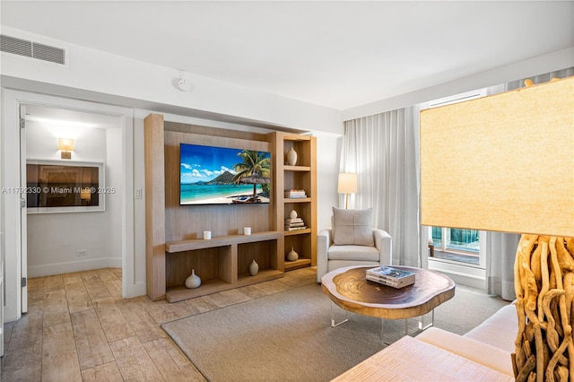 sitting room with baseboards, visible vents, and hardwood / wood-style floors