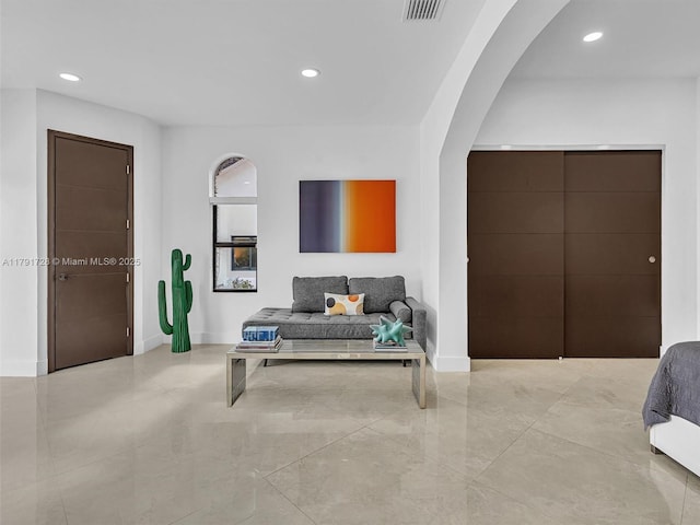 living room with recessed lighting, arched walkways, and visible vents