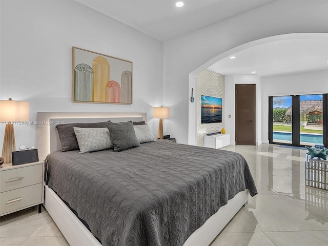 bedroom featuring recessed lighting, arched walkways, and light tile patterned floors